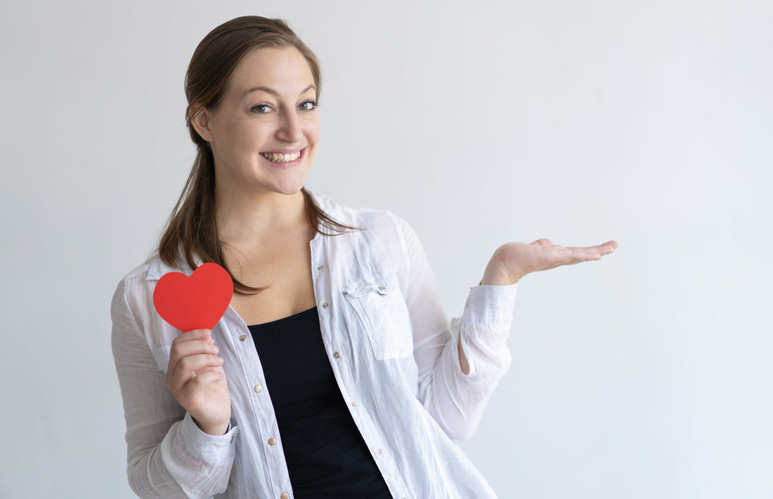 Smiling women holding paper heart